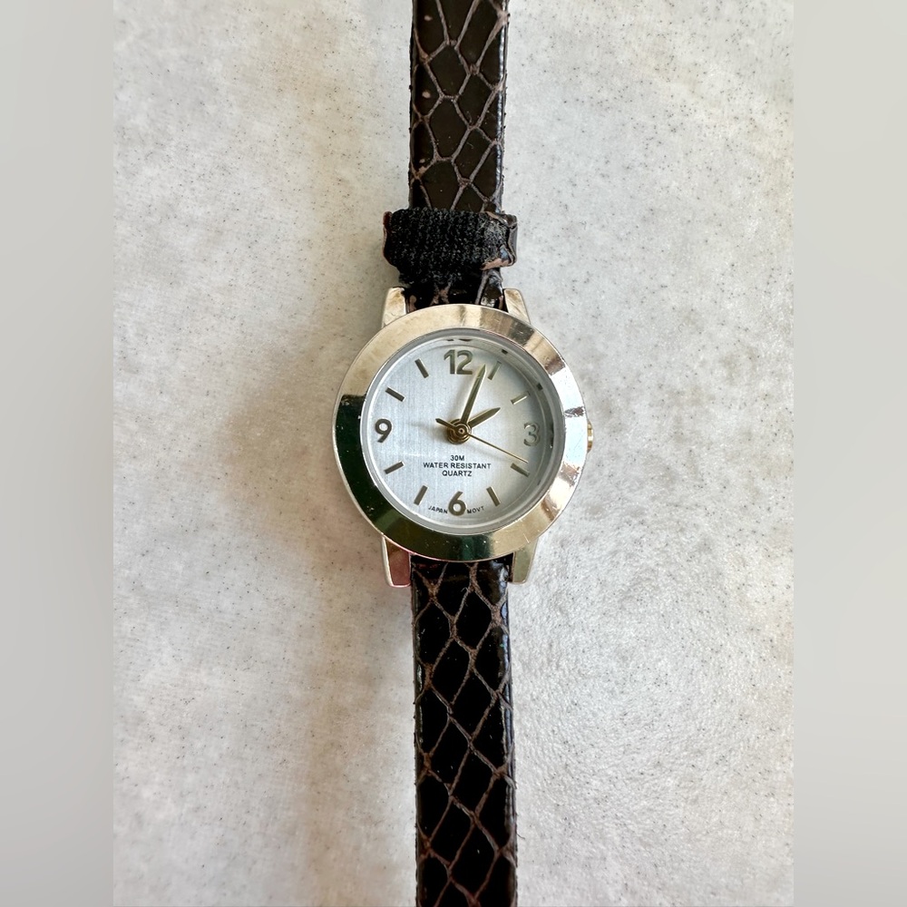 Silver tone watch. Round face.  Gold tone numbers.